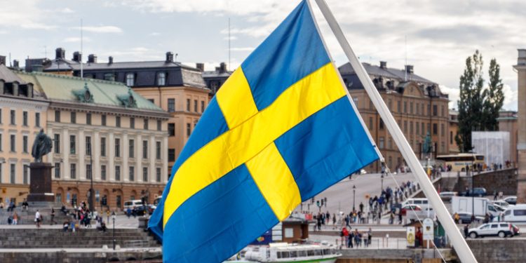 Sweden flag and Stockholm old town Gamla Stan in background