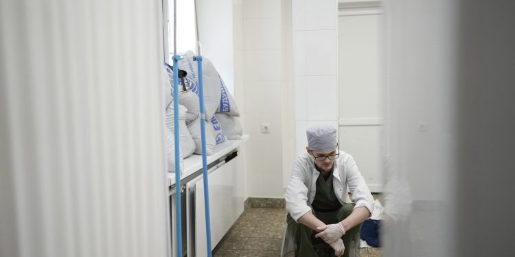 A medical worker reacts after he failed to save the life of Marina Yatsko's 18 month-old son Kirill, who was fatally wounded by shelling, at a hospital in Mariupol, Ukraine, Friday, March 4, 2022. (AP Photo/Evgeniy Maloletka)