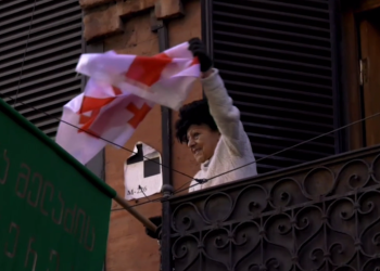 სახალხო პროტესტს გიული ჩოხელი აივნიდან დროშით ხელში ესალმება