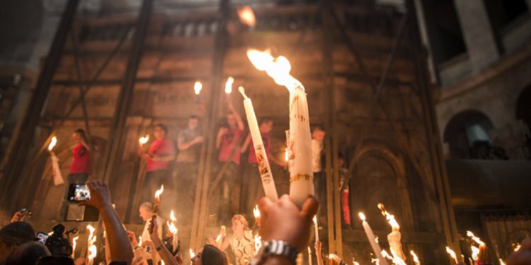 JERUSALEM, ISRAEL - APRIL 19:  Christian Orthodox worshipers hold candles lit from a flame that emerged from the tomb believed to be of Jesus Christ as they take part in the ceremony of the holy fire at the Church of the Holy Sepulcher April 19, 2014 in Jerusalem, Israel. The ancient fire ritual celebrates the Messiah's resurrection after being crucified on the cross.  (Photo by Ilia Yefimovich/Getty Images)