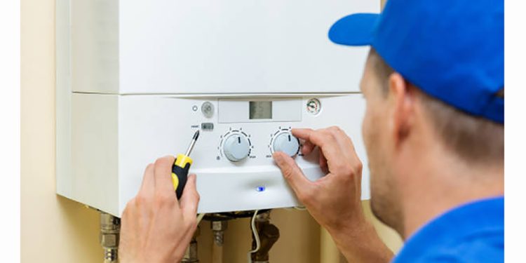 worker set up central gas heating boiler at home