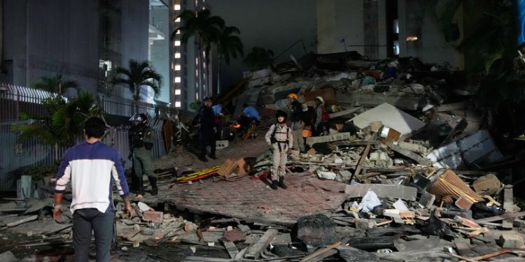 People walk amid debris after an earthquake in Caracas, Venezuela, Wednesday, June 24, 2026. (AP Photo/Ariana Cubillos)